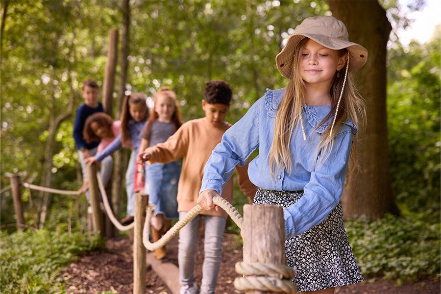 Kinderen in de dierentuin over een evenwichtsbalk aan het lopen